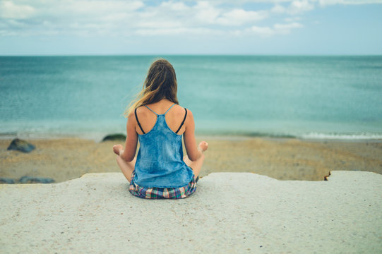 Young woman meditating by the sea