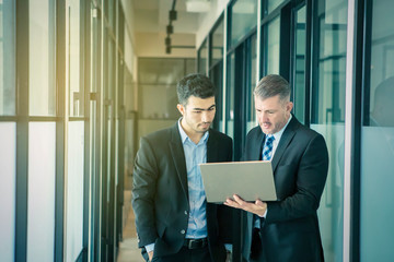 Diverse business people using laptop together