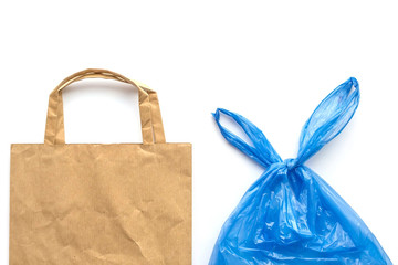 Brown recyclable eco paper bag vs blue plastic bag isolated on white background. Environmental...