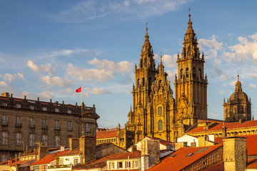 Fototapeta na wymiar Santiago de Compostela Cathedral Towers Close Up with Sun Light Hitting the facade and Tiled Roofs La Coruña Galicia