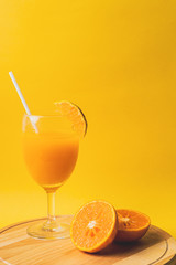 Orange juice on yellow background with woman hand, summer concept background with space