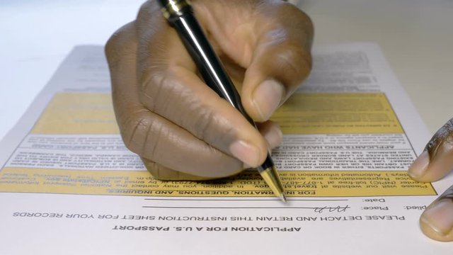 Black african hand filling out USA passaport application form.Migration,USA