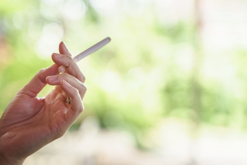 Woman hand holding smoking cigarette