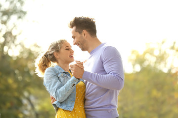 Happy young couple dancing on romantic date in park