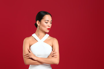 Fashionable Asian woman on color background