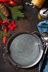 Christmas dinner concept, culinary background. Metal plate, cutlery and napkin on stone countertops. Table setting on a stone countertop. Top view on a flat lay.