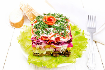 Salad with beef and vegetables on light wooden board