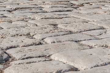 abstract background of an ancient paved stone road close up
