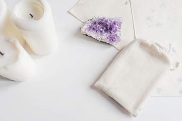 Mock up of tarot deck cotton bag, amethyst and candles on white background. Boho design of tarot cards pouch on white table - obrazy, fototapety, plakaty