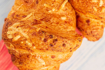 Croissant on a light wooden background. Photographed close-up.