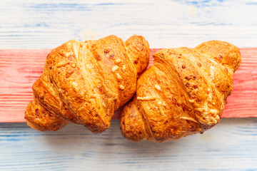 Croissant on a light wooden background. Photographed close-up.