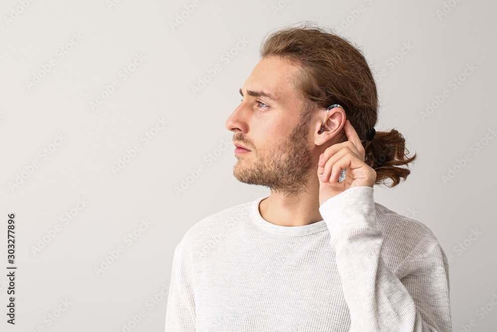 Canvas Prints young man with hearing aid on white background