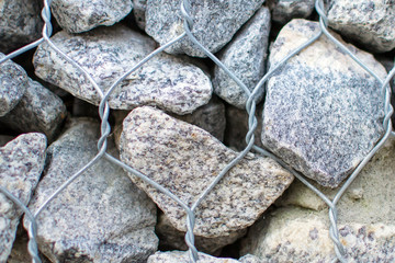 Gabion wall closeup. Textured background. Gabion is stones in wire mesh used for erosion control.