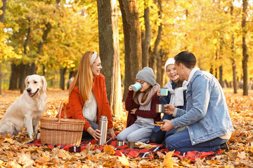 Happy family having picnic in autumn park