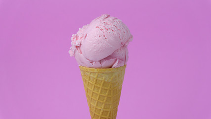 .Strawberry ice cream scoop in waffle cone with on pink background, Closeup Front view Food concept..