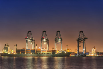 Fototapeta premium Transportation and Shipping Logistics Loading Dock Terminal., Container Import and Export of Sea Freight Transport Industrial., Landscape of Port Maritime and Harbor Cargo Shipyard With Crane Bridge.