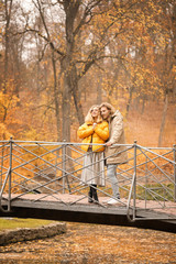 Fototapeta na wymiar Young couple on bridge in autumn park