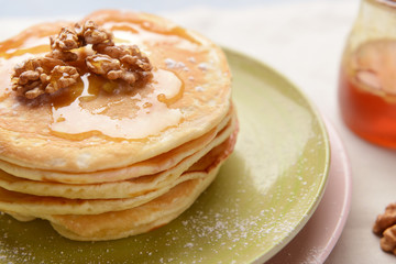 Plate with tasty sweet pancakes on table, closeup
