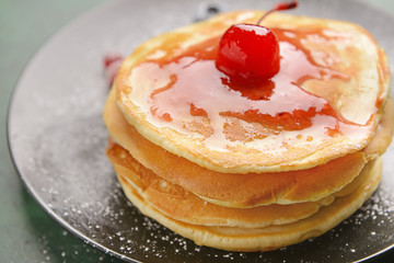 Stack of tasty pancakes with jam on plate, closeup