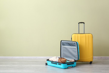 Packed suitcases near color wall. Travel concept