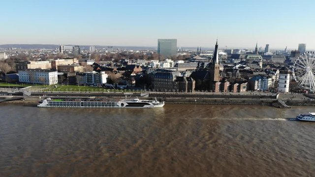 Drone Footage of Duesseldorf Altstadt over the river rhine, city center, in sunny winter weather, going sideways with ships