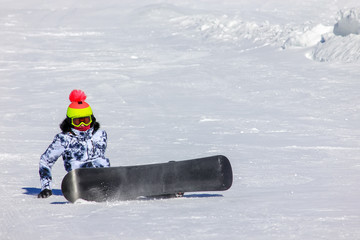 Snowboarding girl on the mountain slope