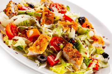 Salad with chicken meat and vegetables on white background