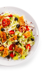 Salad with chicken meat and vegetables on white background