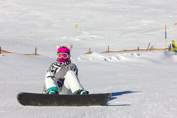 Snowboarding girl on the mountain slope