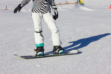 Snowboarding girl on the mountain slope