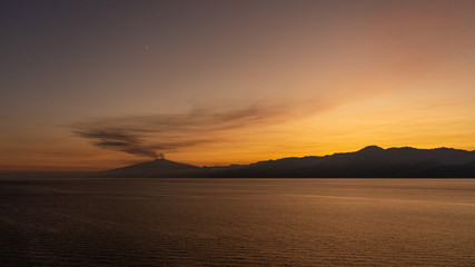 Fototapeta na wymiar etna at sunset view from cruiseship, italy