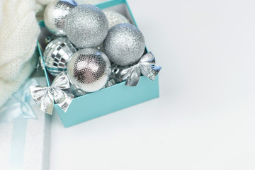 Blue box with silver Christmas balls on the white background, mock up, copy space