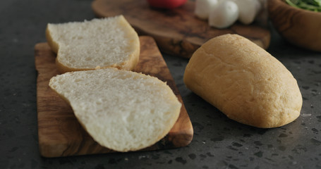 Fototapeta na wymiar sliced ciabatta bread into halves on olive board