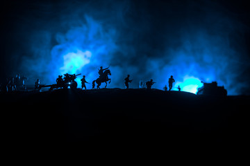 Naklejka na ściany i meble War Concept. Military silhouettes fighting scene on war fog sky background, World War German Tanks Silhouettes Below Cloudy Skyline At night. Attack scene. Armored vehicles and infantry.