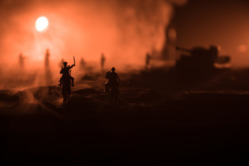 World war officer (or warrior) rider on horse with a sword ready to fight and soldiers on a dark foggy toned background. Battle scene battlefield of fighting soldiers.