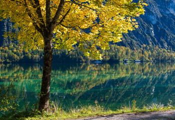 Peaceful autumn Alps mountain lake with clear transparent water and reflections. Almsee lake, Upper Austria.