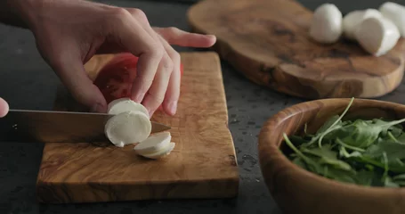 Foto op Plexiglas man slicing small balls of mozzarella on olive board © GCapture