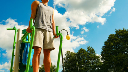 Man flexing arms in outdoor gym