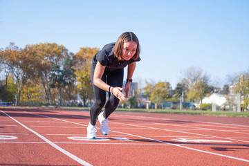 Fototapeta premium Young female runner training in summer day outdoors on the studium 