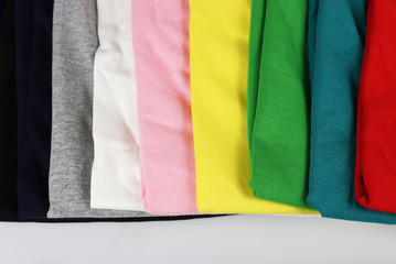 stack of colorful t-shirts on white
