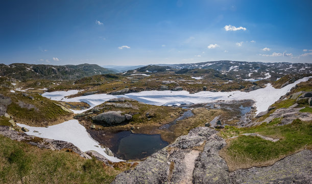 Norwegian mountain landscape with blue sky snow and lakes