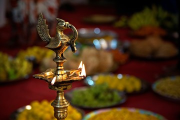 wedding celebration  lighted with holy lamp, garlands and fruits are in the background