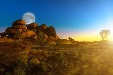 Full moon in australian outback of Devils Marbles rock formations at twilight sunlight sky. Granite boulders of Karlu Karlu Devils Marbles Conservation Reserve Northern Territory, Central Australia. © bennymarty