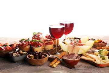 Italian antipasti wine snacks set. Cheese variety, Mediterranean olives, seafood salad, Prosciutto di Parma, tomatoes, anchovy and wine in glasses