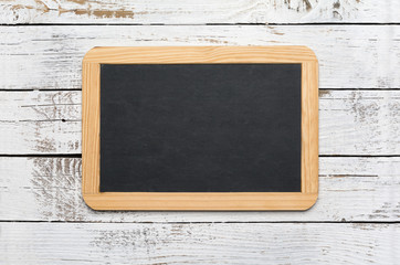 Small vintage blank chalkboard on an old wooden background