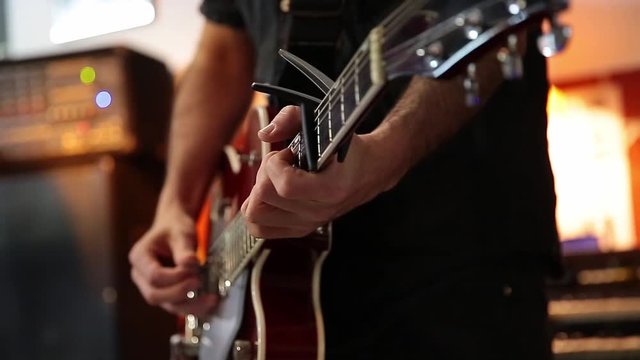 young man playing a beautiful red guitar