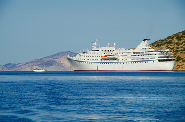 Classic small cruise ship MS Ocean Majesty anchoring in bay on blue sea of Greek Island during...