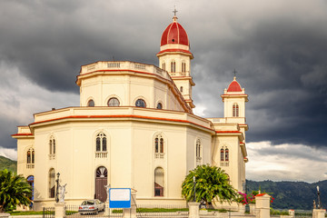 Fototapeta na wymiar Basilica in honour of Our Lady of Charity with black thunder clouds above, El Cobre, Santiago de Cuba, Cuba