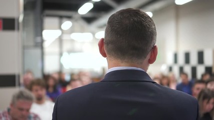 business man presenting training. motivational speech to people in audience hall. male speaker giving presentation in lecture hall at seminar conference. participants education event concept.
