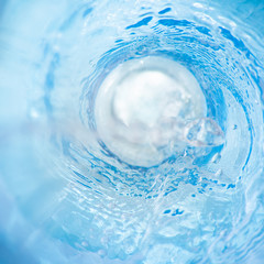 Square background with a swirl of blue clear water is macro, soft focus